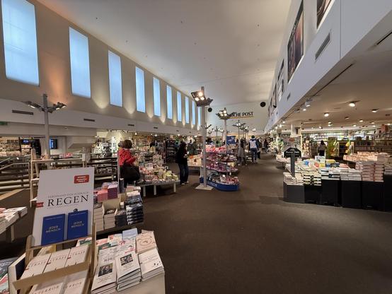 Inside of a rather large shop with stalls with books scattered around the place.
