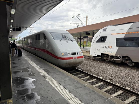 Two train visible. On the left a white high speed train (ICE) and on the right the regional train (RRX).
