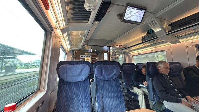 Interior of an ICE 1 train. Empty blue seats in front of me, window left.