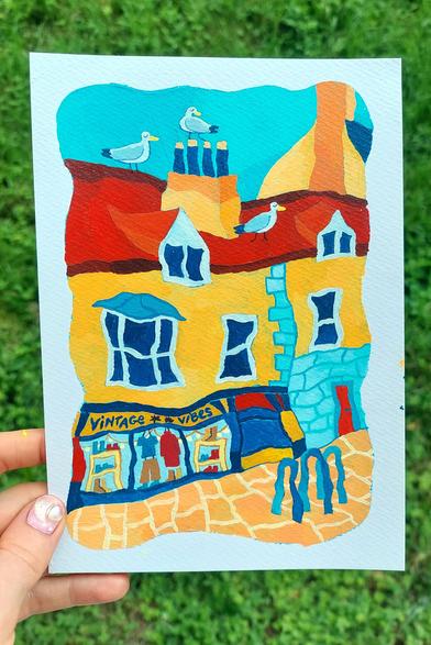 Colorful acrylics painting of the high street of Aberystwyth, Wales, UK. Two terraced houses are directly facing the orange paved street. There are three seagulls on the bright red roof. The facades are bright yellow-orange. On the ground floor, you can see a shop displaying different clothes behind a large window, and a sign over the window reading "Vintage Vibes". Three bike racks are in front of the window.