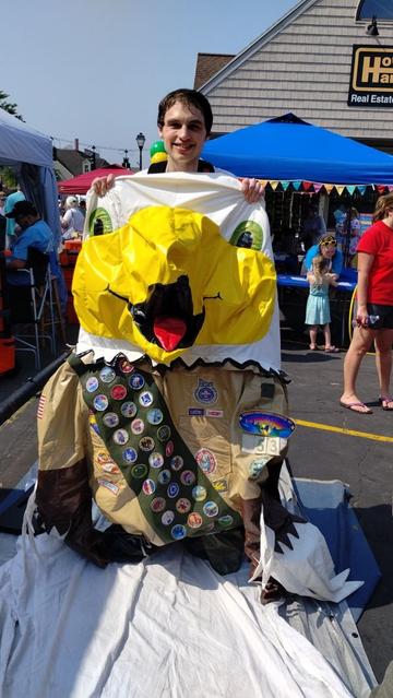 Me holding a deflated eagle costume who is wearing a Class A uniform.