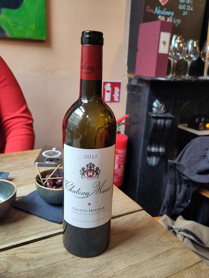 A wine bottle, in a bar.
Musar 2017