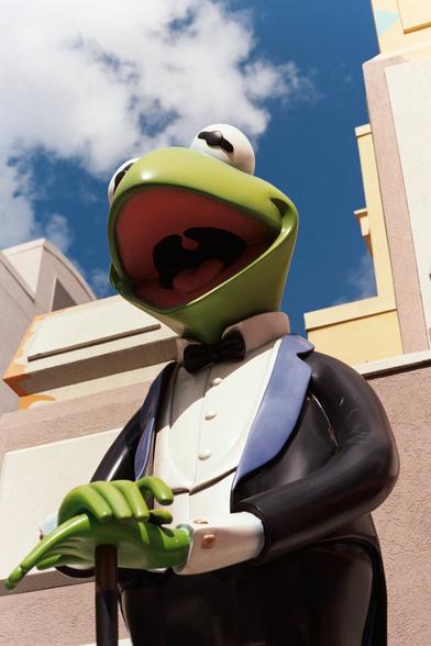 Kermit the Frog statue of him wearing a tuxedo with cufflinks with his hands on top of each other with a cane under the left hand. Shot on Kodak Gold 200 using a Canon AE-1.