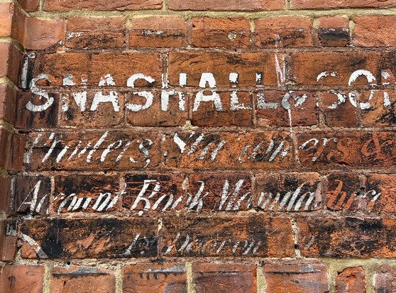White writing on red brick for old accounts book manufacturer