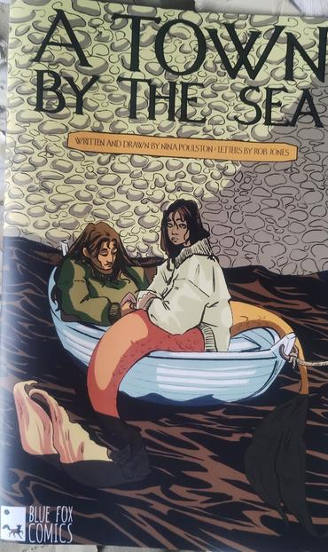 Cover for A Town by the Sea comic by Nina Poulston, showing two merpeople in a rowboat, their fishy tails hanging over the side