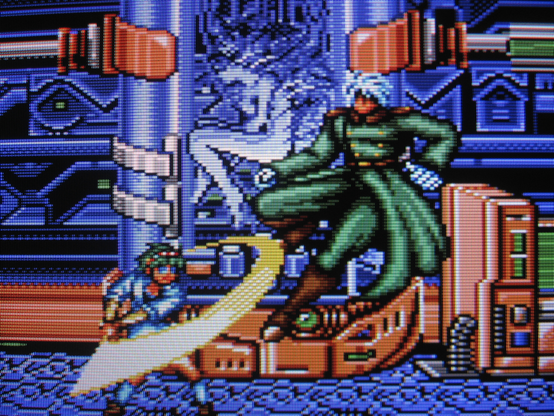 In front of a sci-fi cloning machine Anett swings her sword at a villainous bishounen.