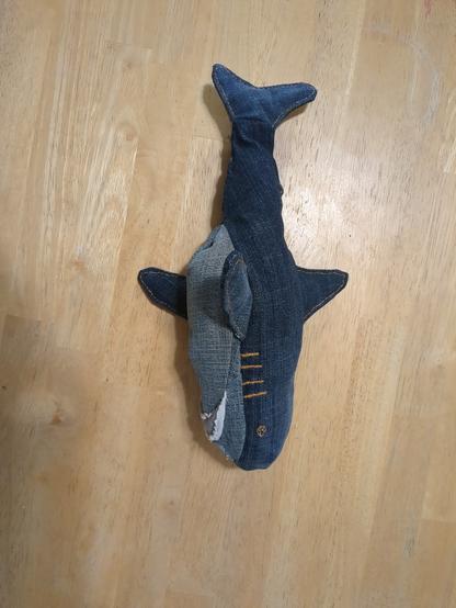 The same shark on its side. Now you can see the light blue belly better, and the mouth, which has teeth made of pocket lining. The part of the mouth that would be pink on an IKEA Blahaj is made of grey denim.
