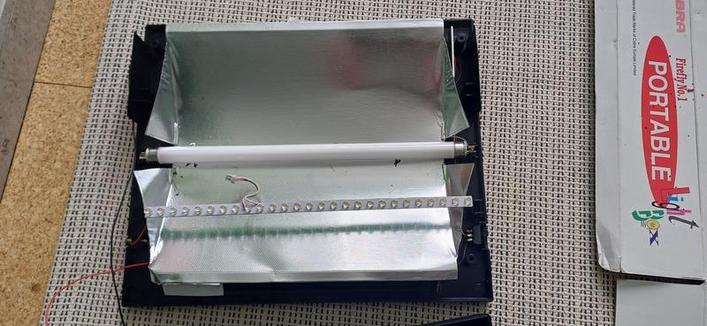 the inside of a light box, there is a light in a metal box of sorts with a small PCB
