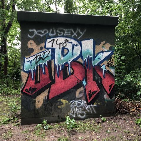 Ein farbenfrohes Graffiti an einem Trafo-Häuschen  mit kleinen Zahlenfolgen dazwischen, so auch eine 8.