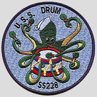 A patch for the USS Drum. A green cartoon octopus beats a drum. Text: U.S.S. Drum SS 228