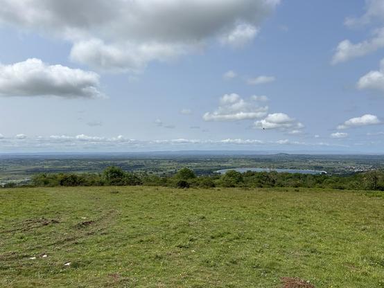 A photo over the Mendip Hills. There is green as far as the eye can see. A reservoir is visible.