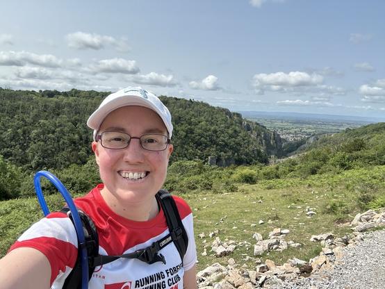 Selfie of Emily with a large stoney gorge behind here, lots of trees cover the edges.
