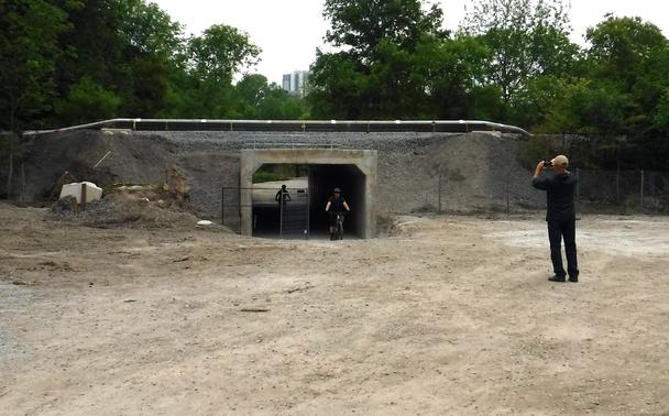 tunnel seen from the east side... two eastbound cyclists are emerging from the tunnel, while a man faces them taking a photo (and of course another man was facing them taking this photo)