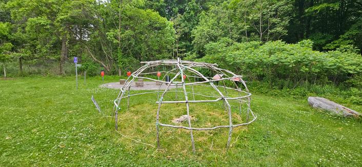 A display at the Bradley Museum in Mississauga of skeletons of tent structure made from small branches.