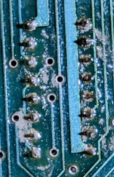 Closeup of the solder side of the board for a 16-pin chip, showing the solder joints reflowed with low-temperature solder.