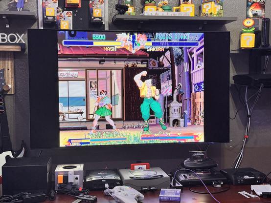 Street Fighter Alpha 2 on a 55” Sakura vs Charlie. A bunch of retro consoles in front of the TV including a mini gaming PC
