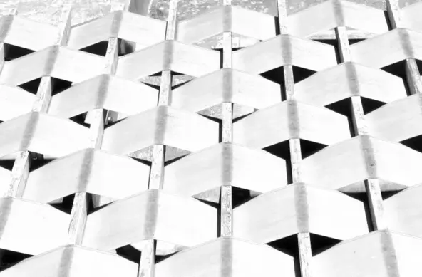 Alternating wrapped fabric in a geometric pattern around wooden planks in a high contrast bright shot.