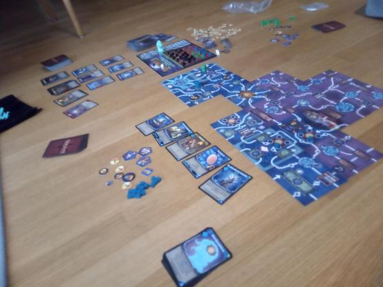 A game of "Clank! Catacombs" in progress. Parts of the board are laid out, sets of cards all around.