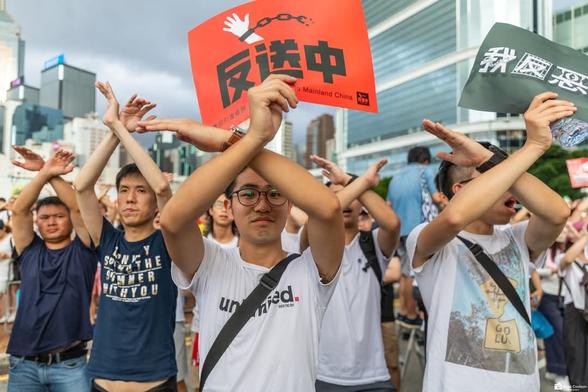 Protesters crossing their arms while holding anti extradition bill banners in Admiralty, Hong Kong.