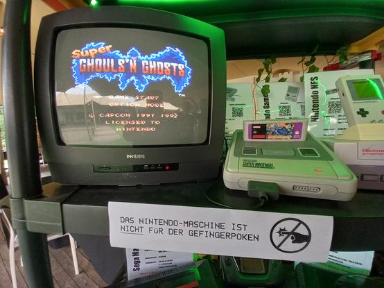 Crt tv displaying ghouls n ghosts title screen on a super Nintendo,  accompanied by a do not touch sign.