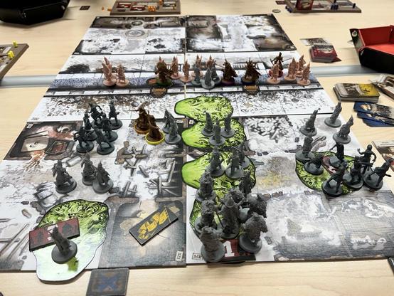 Das Spielbrett von „White Death“ zeigt verschneite Ruine und ist Mitte von einem Wehrgang geteilt. Auf der Mauer stehen die meisten von unseren Helden und Wächtern. Vor der Mauer stehen viel zu viele Zombies. Die giftgrünen Verderbnisfelder sind auch schon viel zu nah an der Mauer… viel zu nah!