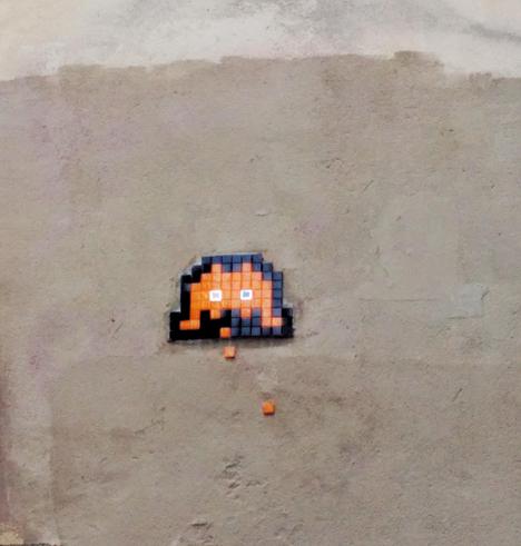 Foto street art. Espace invader en mosaicos naranjas y azules, en una pared parisina, rue quincampoix.