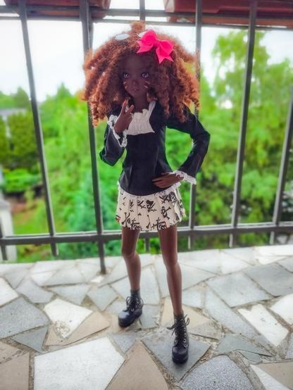 Cocoa Smart Doll wearing a skirt with pirate skulls and a black longsleeve shirt