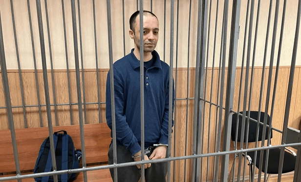 Ruslan Sidiki mit Handschellen gefesselt in einem Käfig vor Gericht