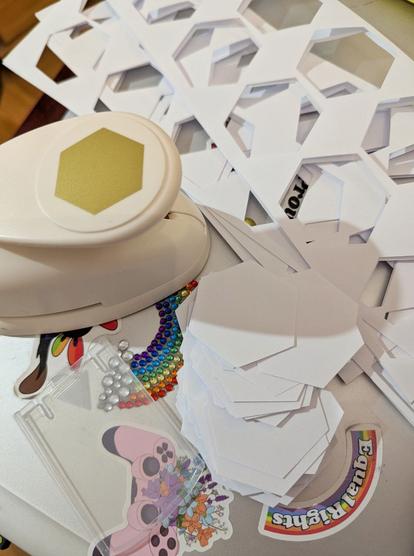 Papierausstanzer mit ausgestanzten Papierhexagonen und Papierresten.