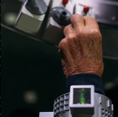Farbfoto nah auf Hand von oben.
Mit ASG am Arm.
Bedient einen der 6 Bleistifftspitzer.