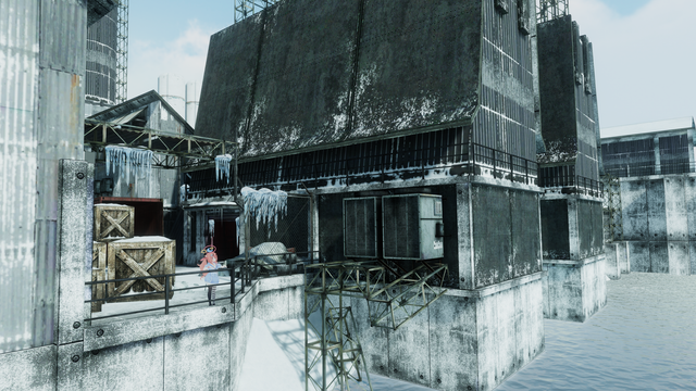View of a facility of some kind near a body of water, covered in snow.