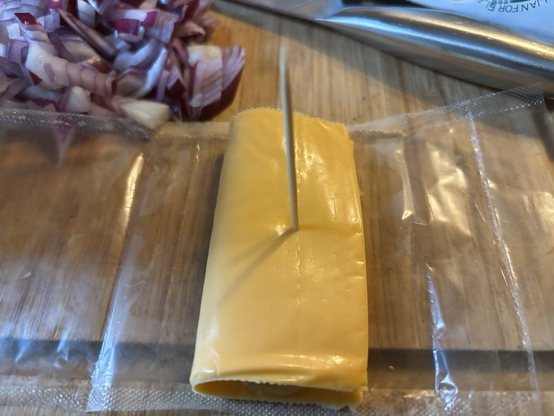 Cheese now folded and enveloped over the gherkin ready for consumption.