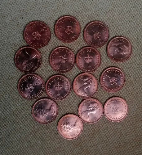 Around 14 pristine copper coloured UK half pence pieces with the head of Queen Elizabeth II on one side and and image of the crown and the half pence denomination the other