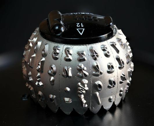 A nice close-up photo of a "type element" from an IBM Selectric typewriter, a roughly spherical metal ball studded with raised alphabetical and numerical characters