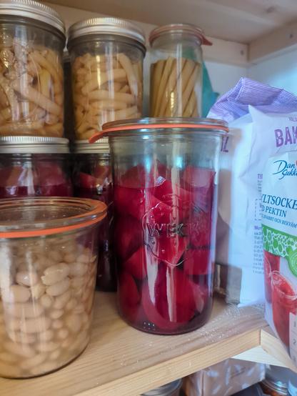 En weckburk med konserverade rödbetor, omgiven av diverse andra konserver och torrvaror.