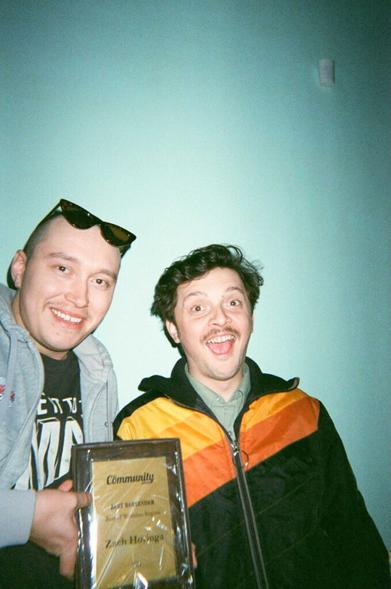 Photo of Kurtis Rideout and The Community Edition Best Bartender award winner Zach Hovinga, smiling and posing with a plaque representing the award.