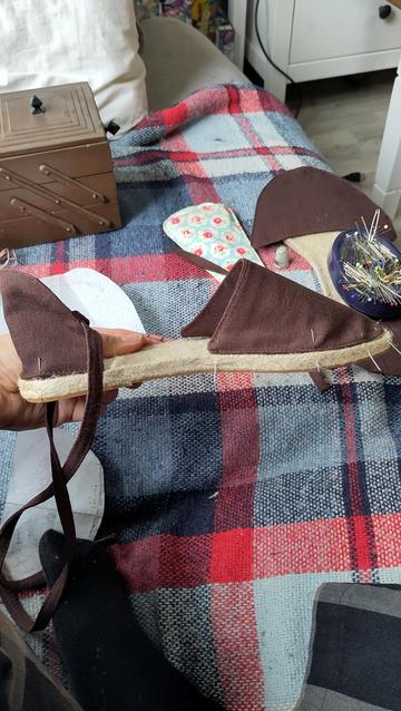 One of the espadrilles with its cover temporarily put together with pins. The heel and toe are covered, the middle is left bare.