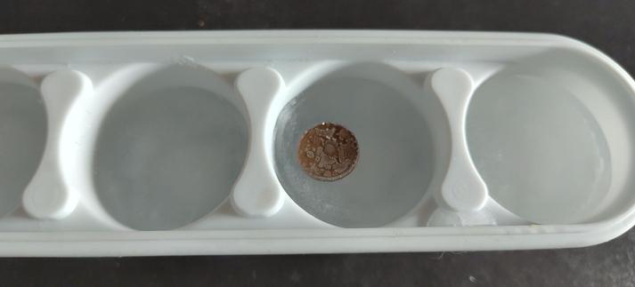 Moneda encima de un bloque de hielo