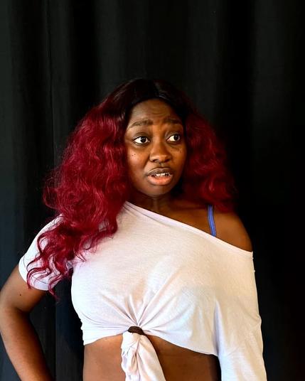 Bambi, avec son crop top et ses cheveux rouges. Elle a l'air surprise d'une remarque que quelqu'un aurait fait hors scène. Certainement une énième pique de sa productrice de mère (vous savez, la dame qui jugeait fort).