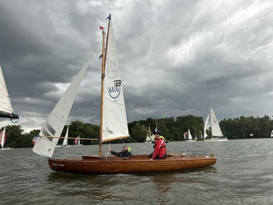 Ein Hölzernes offenes Kielsegelboot auf dem Rhein, im Hintergrund weitere Segelboote .