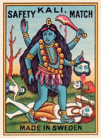 A matchbox cover that says KALI SAFETY MATCH on the top and MADE IN SWEDEN (where Greta Thunberg is from), and shows a simplified scene of the Hindu Goddess Kali in her typical depiction with 4 arms, a severed human head, a bloody sword, a necklace of skulls, a skirt of severed limbs, blue skin, wild hair, etc., standing on a fella