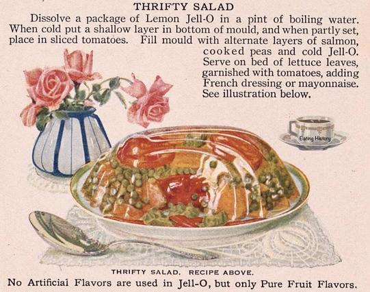 Illustration vintage d'une recette intitulée "Thrifty Salad" (salade économique), montrant un moule de gélatine citronnée (Jell-O) contenant des couches visibles de tomates, petits pois cuits et saumon, servi sur un lit de laitue. Une petite vase avec des roses roses est placée à gauche de l’assiette, et une tasse avec la mention "Eating History" apparaît à droite. Texte explicatif de la recette en haut de l’image, avec mention "No Artificial Flavors are used in Jell-O, but only Pure Fruit Flavors" en bas.