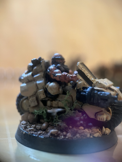 Close up photo of a dwarf mini on a huge motorbike with guns.
