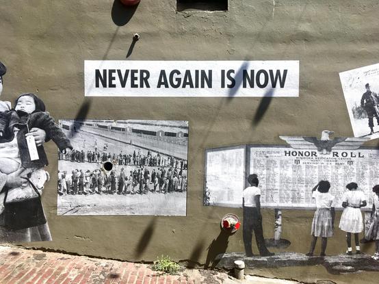 Photograph of public mural by artist Erin Shigaki who "showcases larger-than-life historic photos under the banner, “Never Again Is Now.” In this space, history meets art to invite you to explore the often unseen community treasures in Japantown and reflect on the meaning of the past for today."