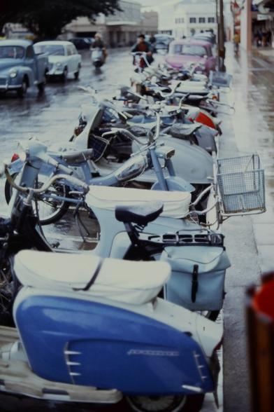 A row of mopeds parked in a line