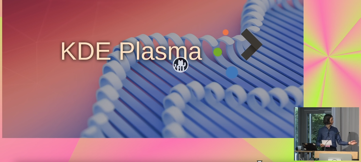A view of a slide depicting KDE Plasma 6.4. MA Barbe, the speaker, can be seen in an inset in the bottom right hand corner.