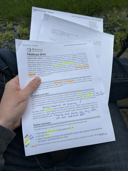 Highlighted printouts of mDNS-related articles and specs.
