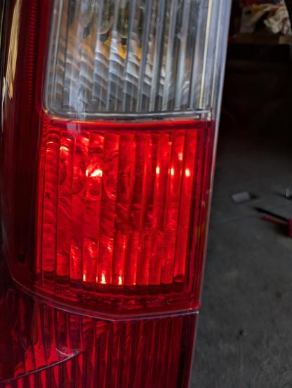 A taillight assembly attached to a car. The brake light is illuminated.