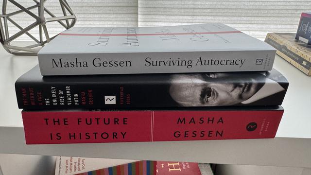 photo of 3 books by M. Gessen stacked on a shelf: Surviving Autocracy, The Unlikely Rise of Vladimir Putin, and The Future is History. All 3 spines are white, red, and black.