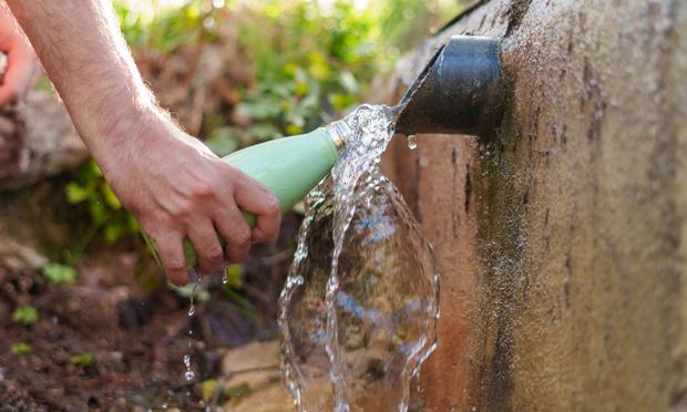 Una persona llenando de agua una botella de aluminio (Javier Zayas Photography vía Getty Images)